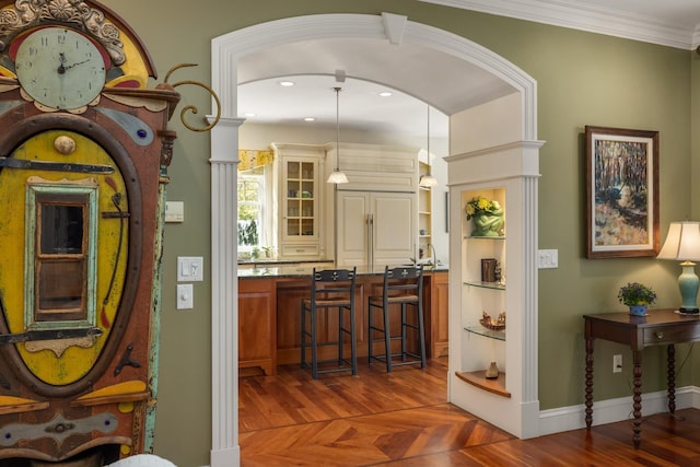 interior space with recessed lighting, parquet flooring, baseboards, ornamental molding, and decorative light fixtures