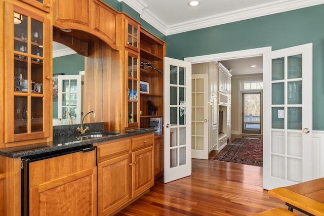 bar featuring crown molding, french doors, a sink, and dark wood-style flooring