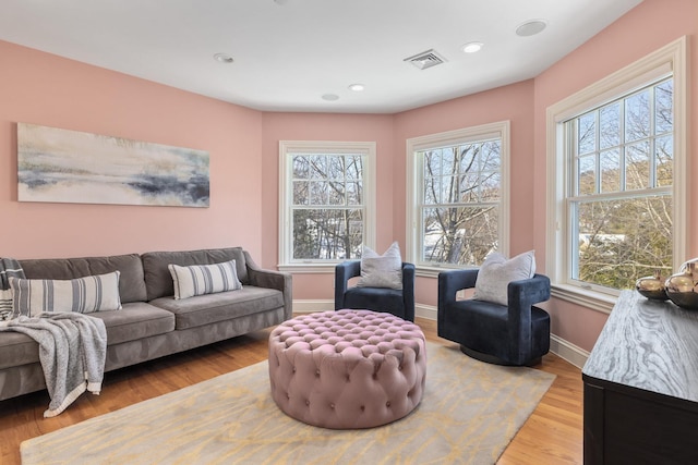 living room featuring baseboards, visible vents, wood finished floors, and recessed lighting