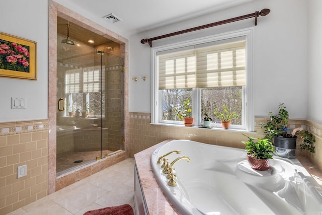 bathroom featuring a garden tub, tile walls, visible vents, a shower stall, and tile patterned floors