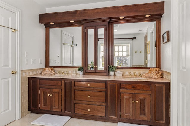 full bath featuring double vanity, a sink, tile walls, and tile patterned floors