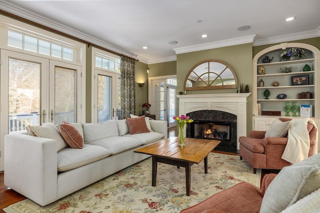 living room with ornamental molding, wood finished floors, french doors, a fireplace, and recessed lighting