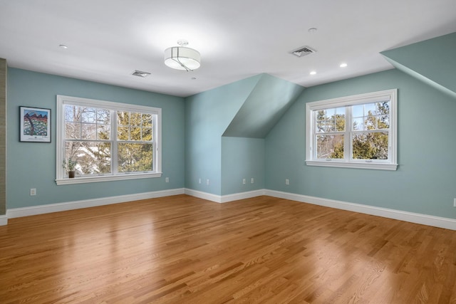 bonus room with baseboards, visible vents, and wood finished floors