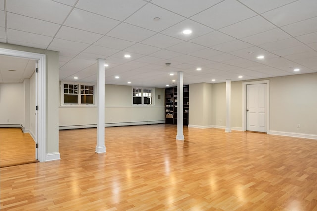 finished basement with light wood-style floors, recessed lighting, baseboards, and baseboard heating