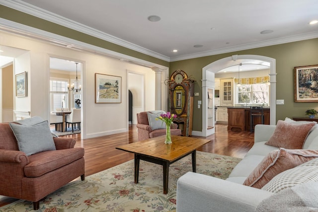 living area with dark wood-style flooring, plenty of natural light, and crown molding