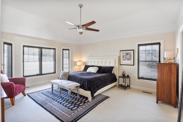 bedroom featuring ornamental molding, multiple windows, visible vents, and light colored carpet