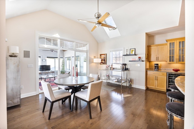 dining room with a healthy amount of sunlight, beverage cooler, dark wood finished floors, and a ceiling fan