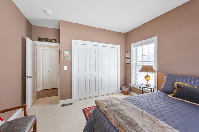 carpeted bedroom with baseboards and a closet