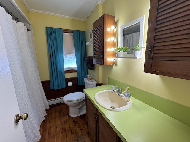 bathroom with toilet, a baseboard radiator, ornamental molding, wood finished floors, and vanity