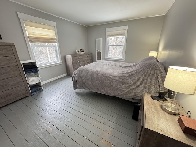 bedroom with wood-type flooring, ornamental molding, and baseboards