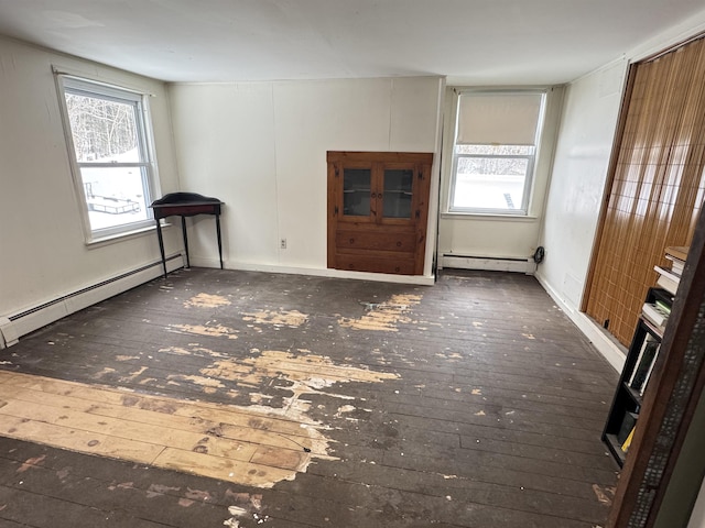 unfurnished living room featuring a baseboard heating unit and wood-type flooring