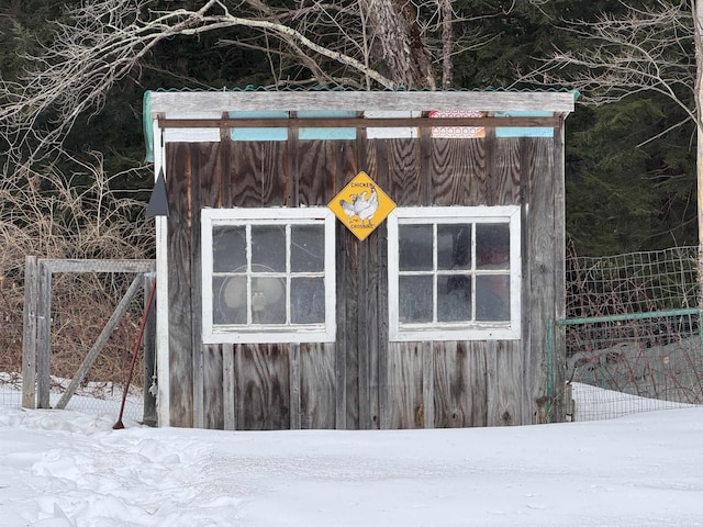 snow covered structure with fence