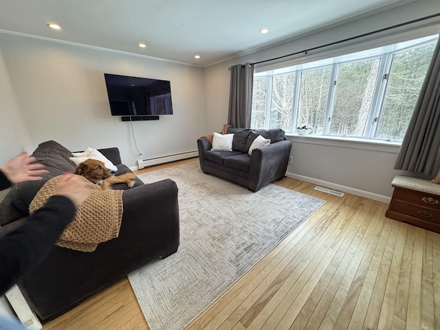 living room with light wood-style flooring, a baseboard heating unit, visible vents, baseboards, and ornamental molding