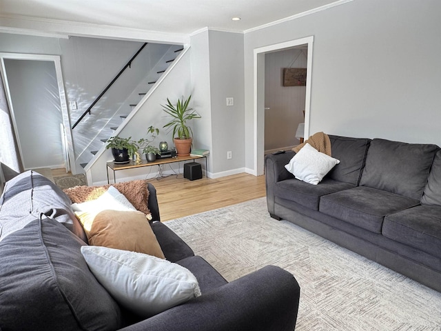 living area with ornamental molding, stairway, baseboards, and wood finished floors