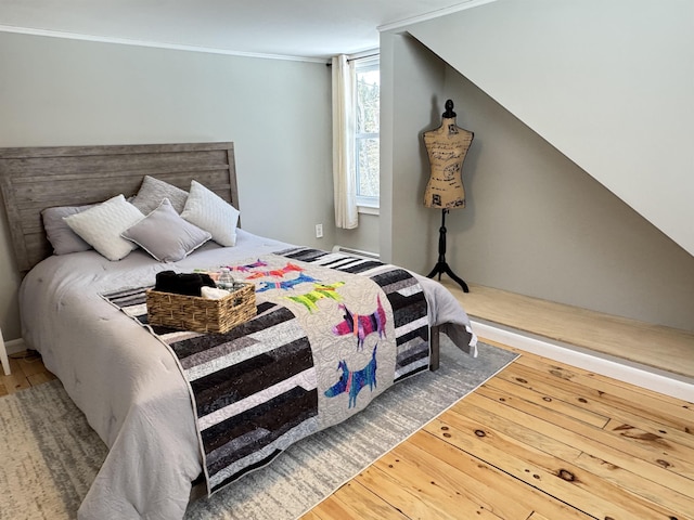 bedroom featuring hardwood / wood-style flooring and crown molding