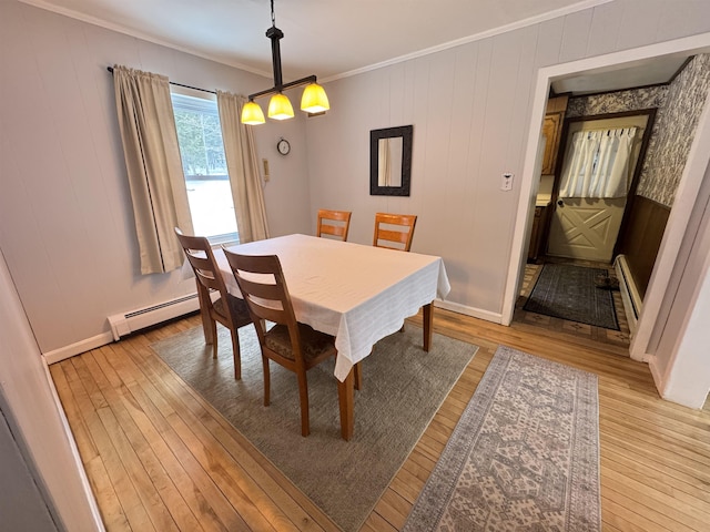 dining room with light wood-type flooring, a baseboard radiator, baseboards, and crown molding