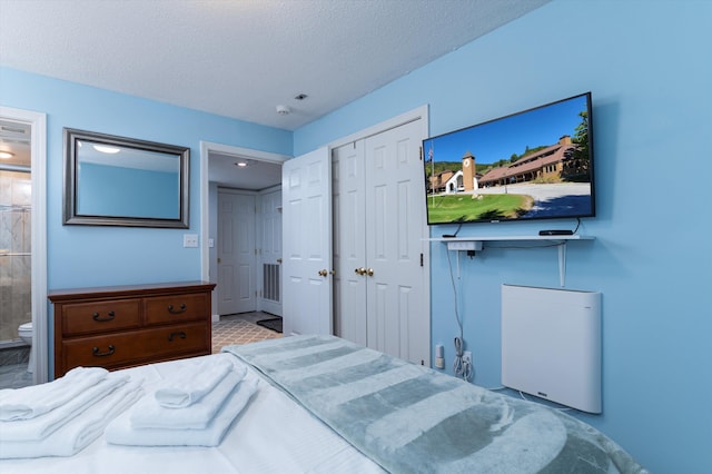 bedroom featuring a closet, a textured ceiling, and ensuite bath