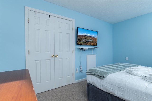 carpeted bedroom featuring a textured ceiling and a closet