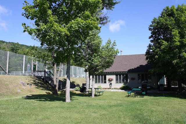 view of front of property with roof with shingles and a front lawn