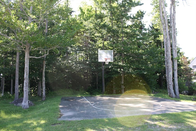 view of basketball court with community basketball court and a lawn