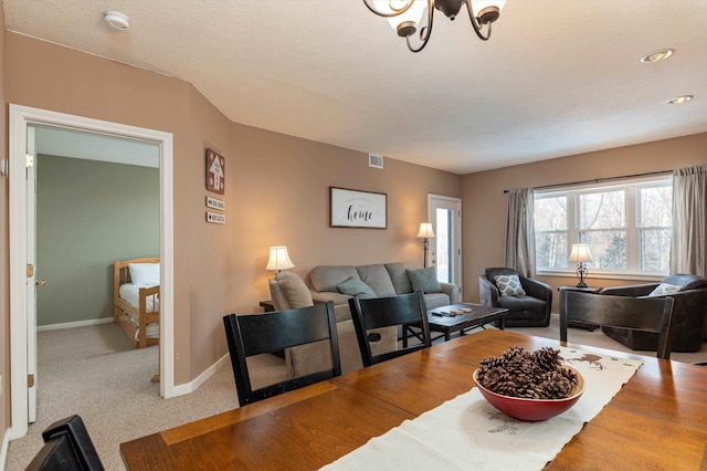 living room with carpet, visible vents, a textured ceiling, a chandelier, and baseboards