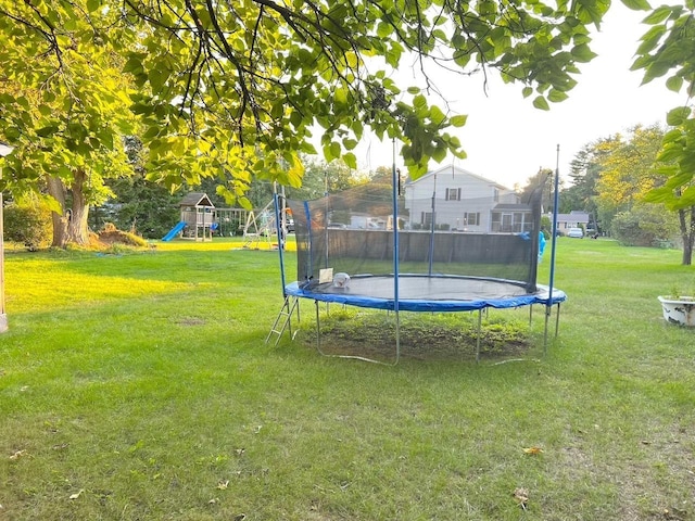 view of yard with a trampoline and a playground