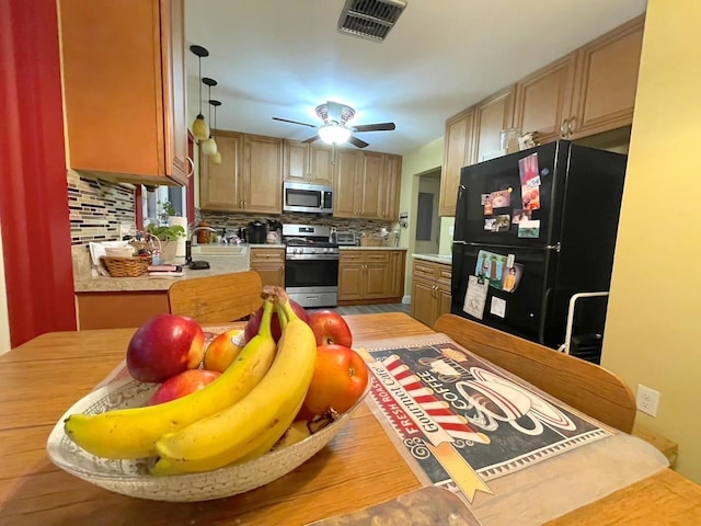 kitchen with tasteful backsplash, visible vents, appliances with stainless steel finishes, light countertops, and a sink