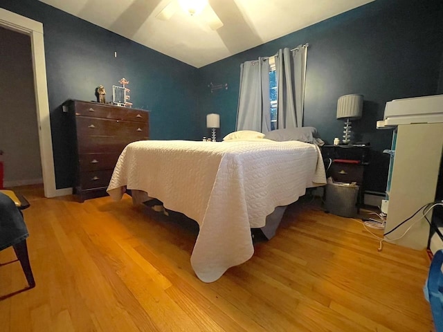 bedroom featuring lofted ceiling and wood finished floors