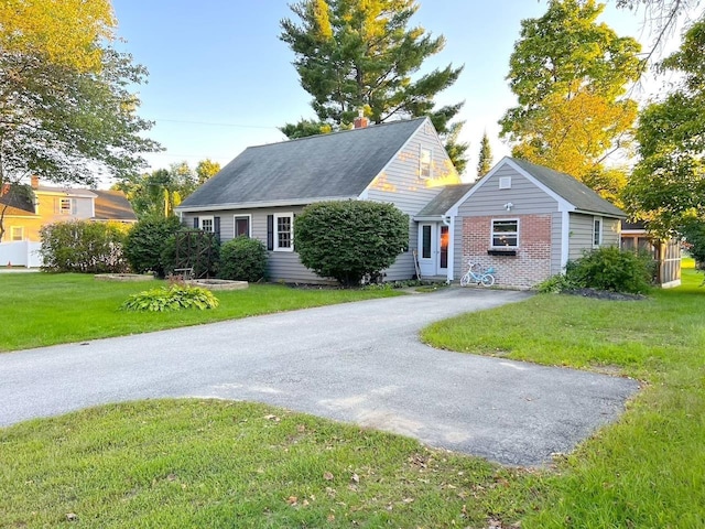 view of front of house with brick siding, aphalt driveway, and a front yard