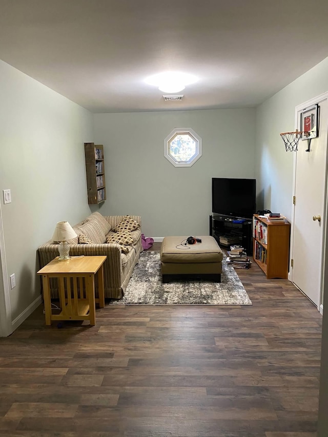 living room with visible vents, baseboards, and wood finished floors