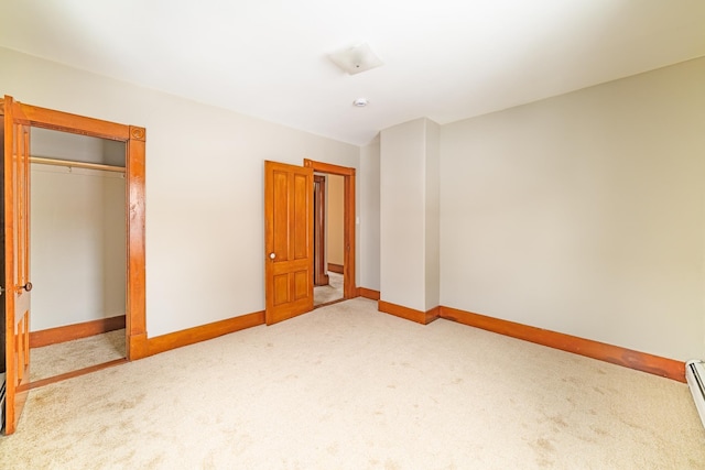 unfurnished bedroom with a baseboard radiator, a closet, light colored carpet, and baseboards