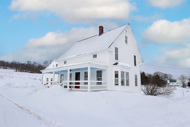 exterior space featuring covered porch and a chimney