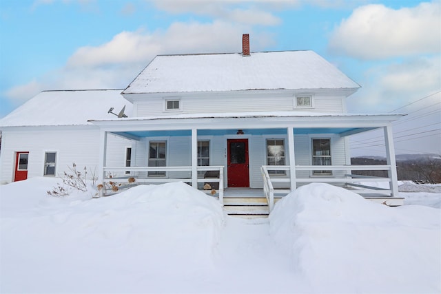 view of front of home featuring covered porch and a chimney