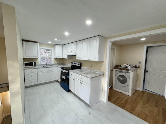 kitchen featuring washer / dryer, electric stove, white microwave, marble finish floor, and under cabinet range hood