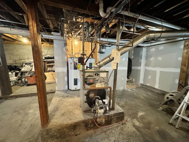 unfinished below grade area featuring a heating unit, electric water heater, and concrete block wall