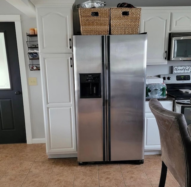 kitchen featuring stainless steel appliances, white cabinets, and light tile patterned floors