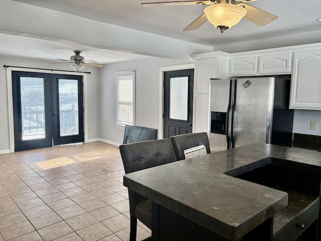 dining space with light tile patterned floors, baseboards, and a ceiling fan