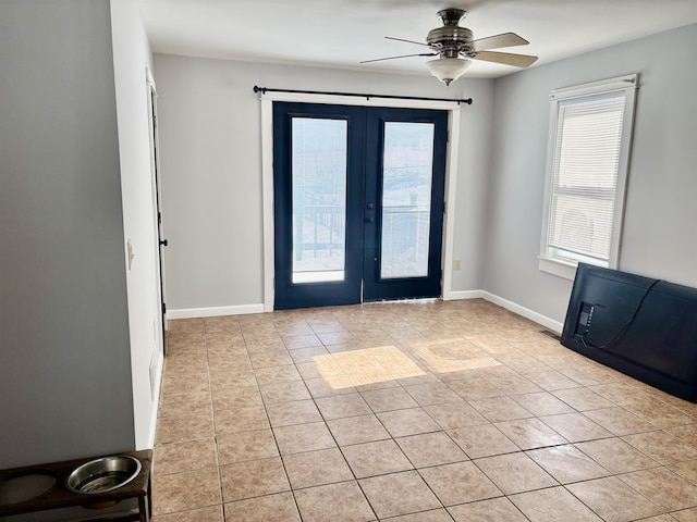 entryway featuring light tile patterned floors, ceiling fan, and baseboards