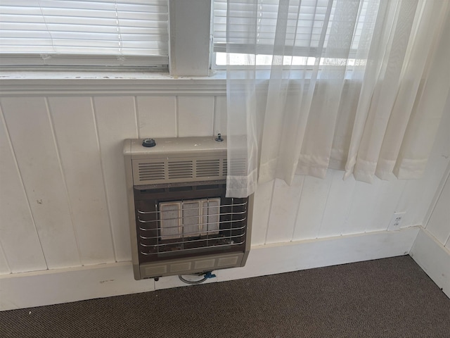 room details with carpet floors, a decorative wall, and heating unit