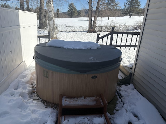 yard covered in snow featuring fence and a hot tub