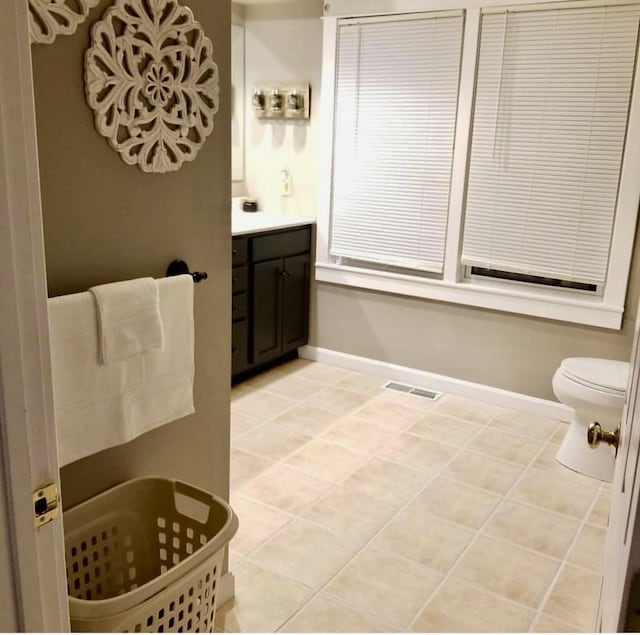 bathroom featuring baseboards, visible vents, tile patterned flooring, and vanity