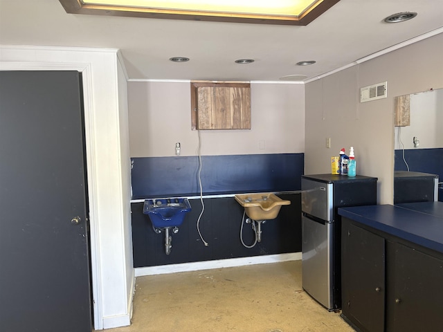 interior space featuring visible vents, dark countertops, freestanding refrigerator, concrete floors, and a sink