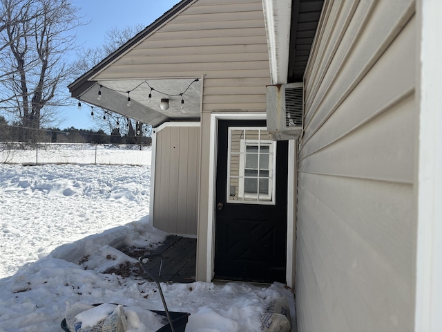 snow covered property entrance with fence