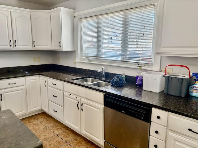 kitchen featuring light tile patterned floors, a sink, white cabinets, dishwasher, and dark stone countertops