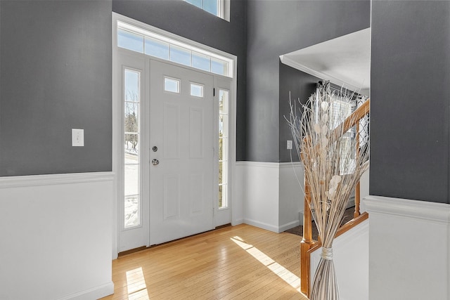 foyer featuring hardwood / wood-style flooring, a high ceiling, and wainscoting