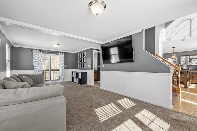 living area featuring stairway, a chandelier, crown molding, and carpet flooring