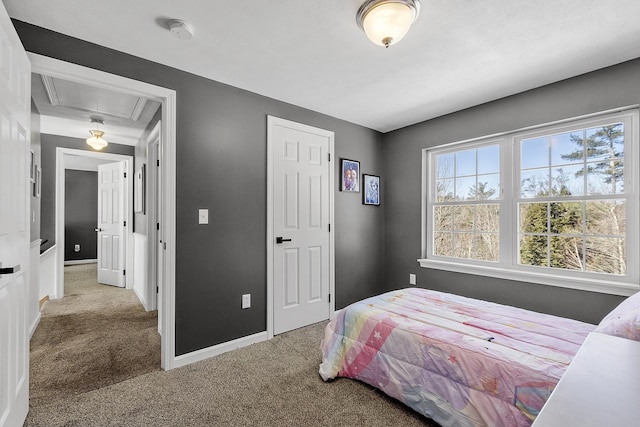 bedroom with attic access, carpet flooring, and multiple windows