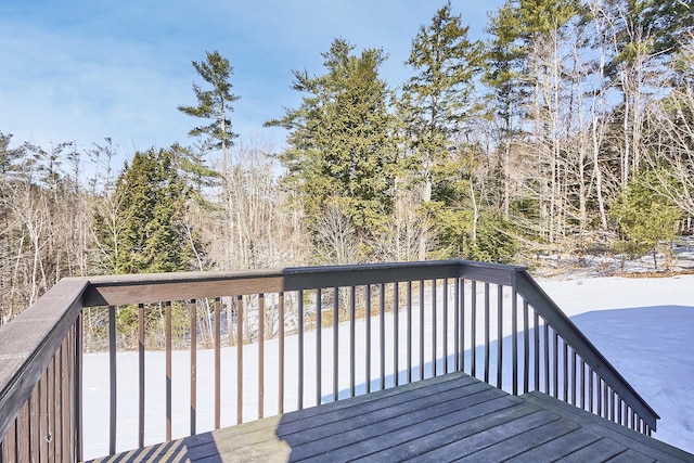 wooden terrace featuring a view of trees