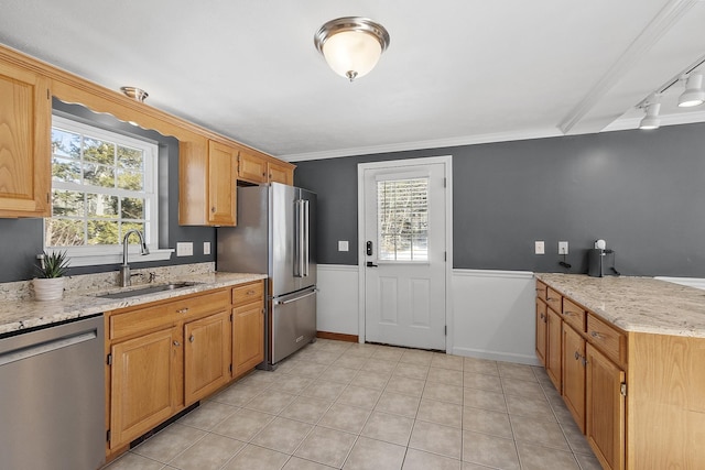 kitchen featuring crown molding, appliances with stainless steel finishes, light tile patterned flooring, a sink, and a peninsula