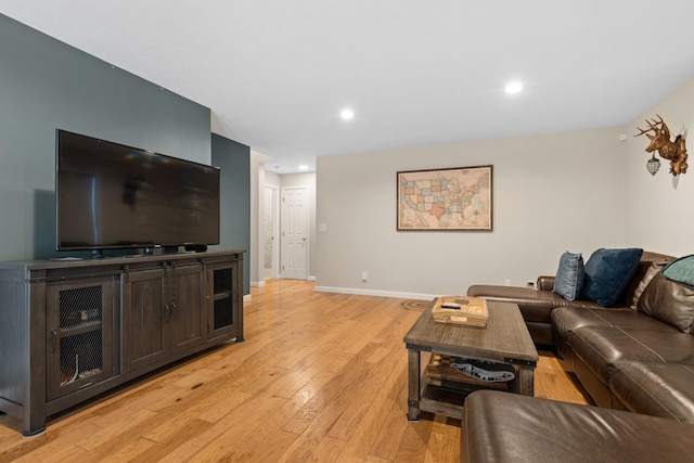 living room featuring baseboards, recessed lighting, and light wood-style floors